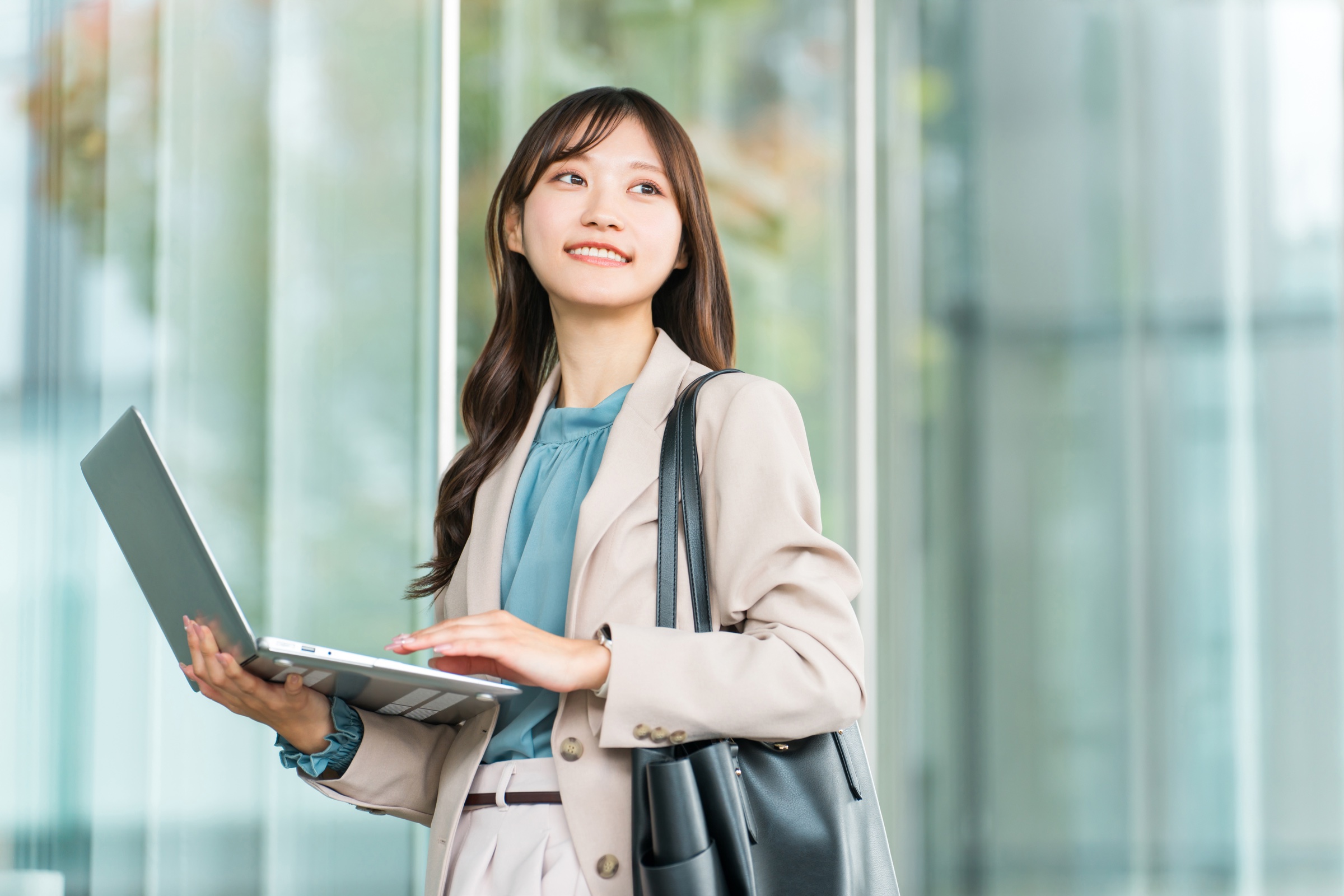 ノートパソコンを持ち、これからの仕事について考える若手社会人